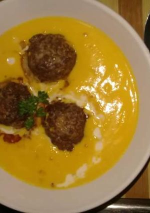 A picture of Creamy pumpkin soup and meatballs.