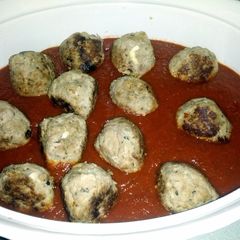 A picture of mozzarella stuffed turkey meat balls in a red sauce..