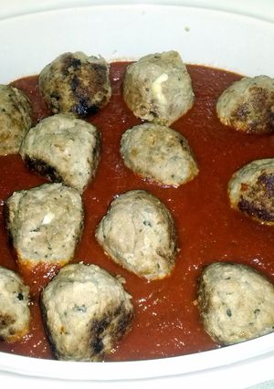 A picture of mozzarella stuffed turkey meat balls in a red sauce..