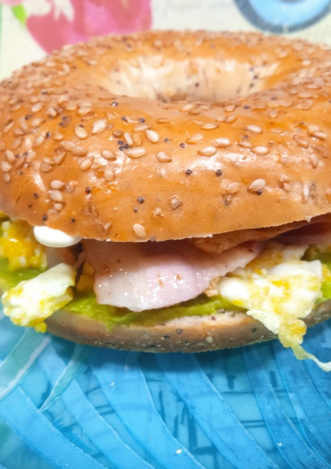 Una foto de Bagel con guacamole, huevo y bacon