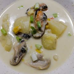 A picture of Seafood chowder with coconut, corn and mussels.