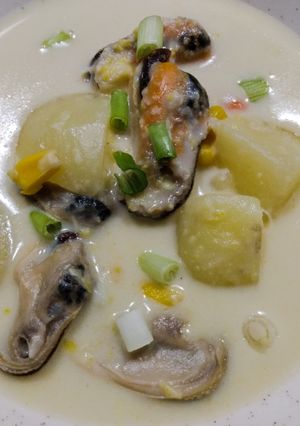 A picture of Seafood chowder with coconut, corn and mussels.