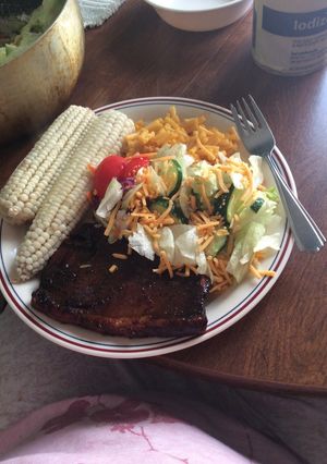 A picture of Pork Chop Fresh Corn Mac & Cheese And Salad.