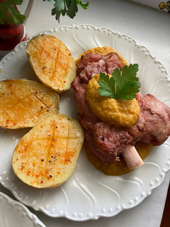 Foto principal de Codillo de cerdo con salsa de verduras y patatas asadas