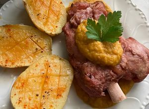 Foto principal de Codillo de cerdo con salsa de verduras y patatas asadas