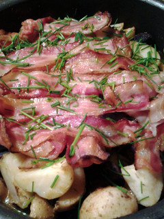 A picture of roasted potatoes and bacon.