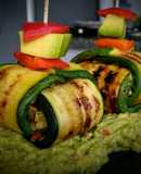 Hojas de calabacín asadas rellenas con vegetales sobre guacamole