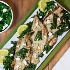 A picture of Marinated grilled chicken with sauteed kale and spinach.
