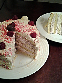 A picture of White Butter Cake layered with Raspberry Cream with a White Chocolate Frosting.