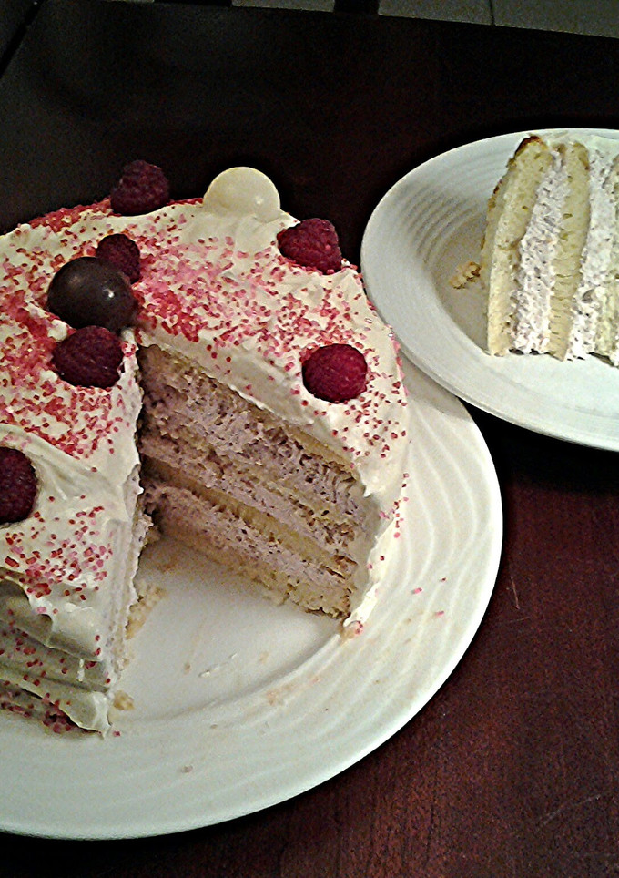 A picture of White Butter Cake layered with Raspberry Cream with a White Chocolate Frosting.