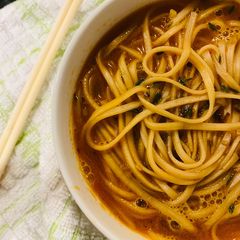 A picture of Prawn head and noodle soup.