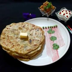 A picture of Aloo paratha with kashmiri dum aloo dum & Kesar pista shrikhand (Breakfast).