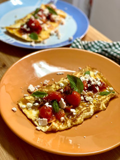 Una foto de Tortilla jugosa con tomates confitados, feta y albahaca