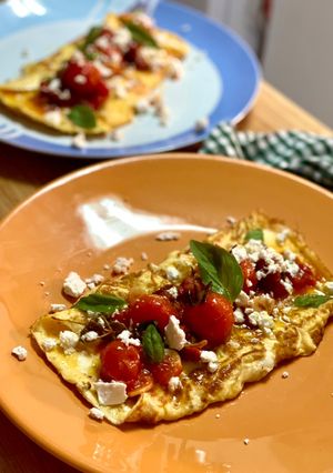 Una foto de Tortilla jugosa con tomates confitados, feta y albahaca