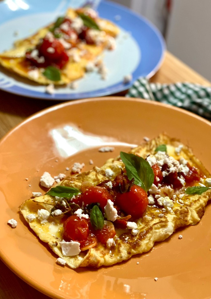 Una foto de Tortilla jugosa con tomates confitados, feta y albahaca