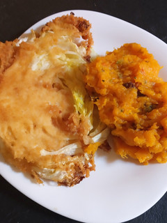 Una foto de Milanesa de repollo con puré de calabaza, espinacas y pasas