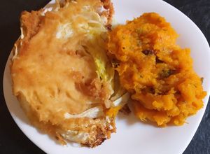 Una foto de Milanesa de repollo con puré de calabaza, espinacas y pasas
