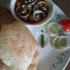A picture of Chole with stuffed bhature.