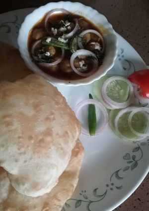 A picture of Chole with stuffed bhature.