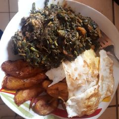 A picture of Fried plantain, fried egg with sauced vegetable.