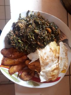 A picture of Fried plantain, fried egg with sauced vegetable.
