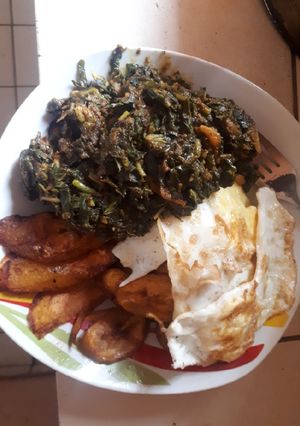A picture of Fried plantain, fried egg with sauced vegetable.