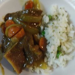 A picture of Curried Goat with Parsley Pea Rice.