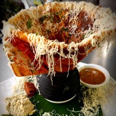 A picture of Cone cheesy Masala Dosa with Coconut Tomato Curry.
