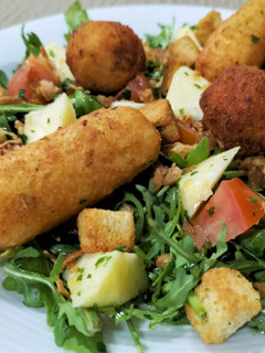 Una foto de Ensalada de rúcula con albóndigas de bacalao y delicias de pulpo