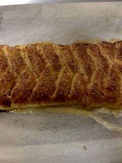 Una foto de Trenza de hojaldre rellena de queso crema, jamón de york y cheddar
