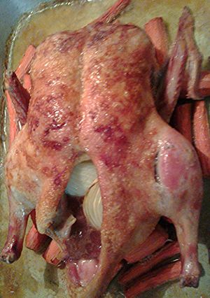 A picture of Roasted Duck on a bed of carrots.