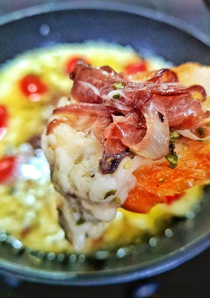 Una foto de Queso provolone fundido con cebollas caramelizadas
