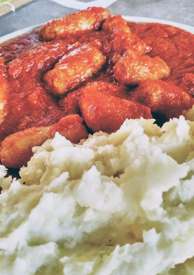 Una foto de Salchichas con tomate y puré de patatas 🥔