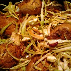 A picture of chicken in a nest of cabbage.