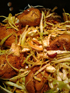 A picture of chicken in a nest of cabbage.