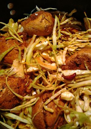 A picture of chicken in a nest of cabbage.