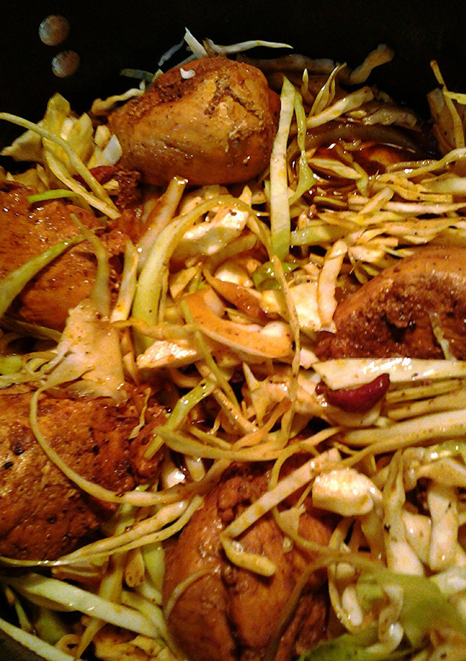 A picture of chicken in a nest of cabbage.