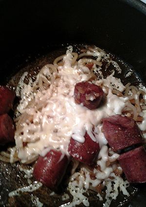 A picture of Udon noodles cheese and sausage.