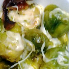 A picture of Brussel sprouts with bacon and cheese.
