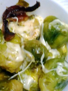 A picture of Brussel sprouts with bacon and cheese.