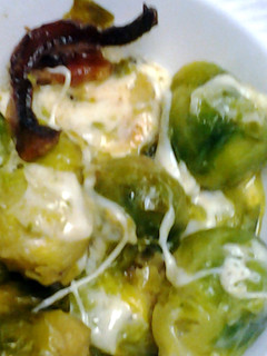 A picture of Brussel sprouts with bacon and cheese.