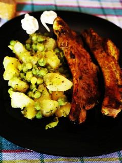 Una foto de Costillas de cerdo en adobo con patata y guisantes salteadas