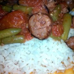 A picture of stewed tomatoes and sausage.