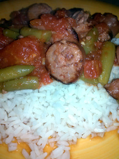 A picture of stewed tomatoes and sausage.
