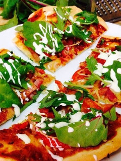 A picture of Cheese & Bacon Pizza with Leafy Greens.
