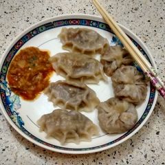 A picture of Steamed veg Dumplings with spicy tomato chutney.