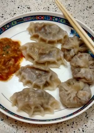 A picture of Steamed veg Dumplings with spicy tomato chutney.