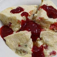 A picture of Butterscotch pudding with strawberry sauce.