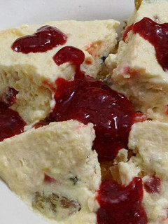 A picture of Butterscotch pudding with strawberry sauce.