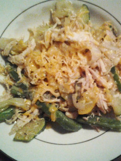 A picture of Veggies and chicken with cheese.